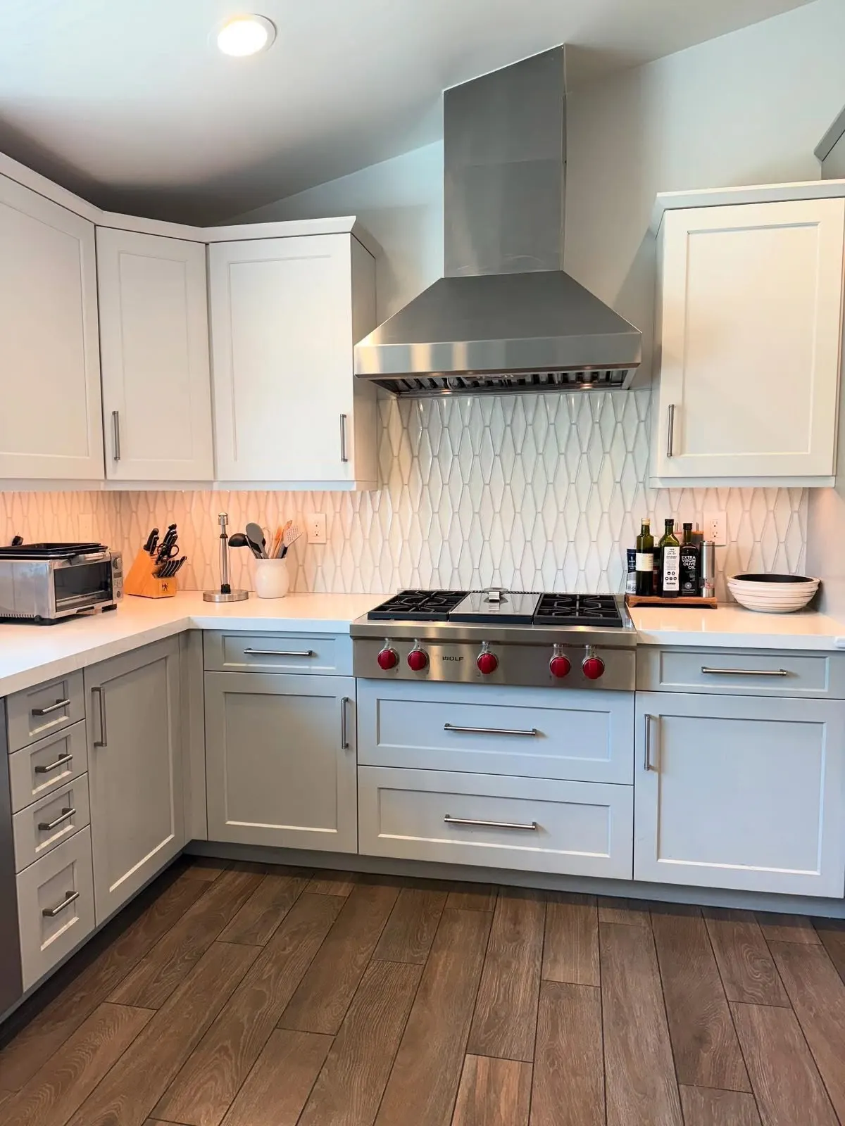 Clean kitchen with white cabinets and gas range after a deep cleaning in Orange County